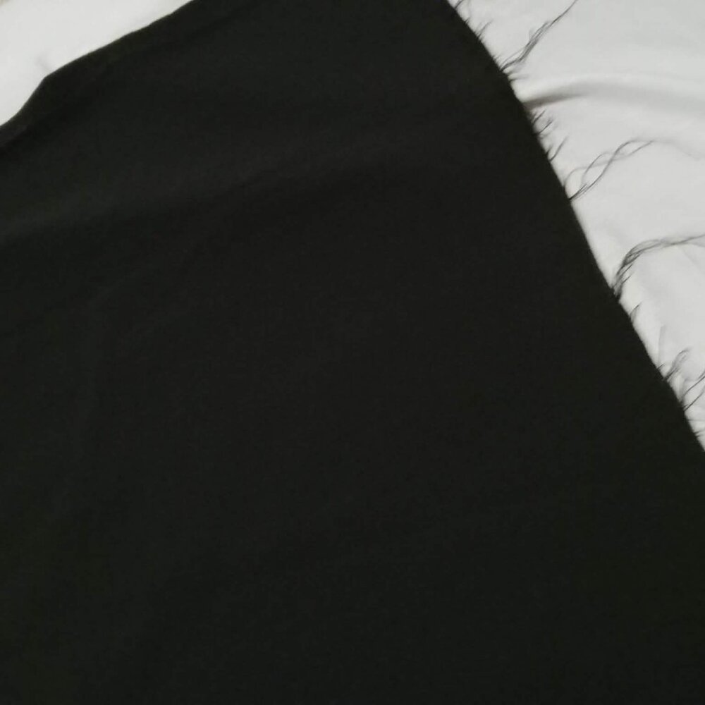 End of roll of luxurious black polyester and spandex fabric with slight texture